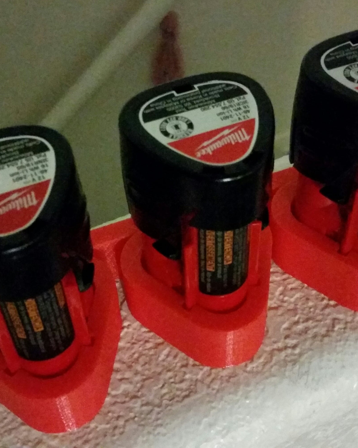 Vägghållare för tre Milwaukee M12-batterier