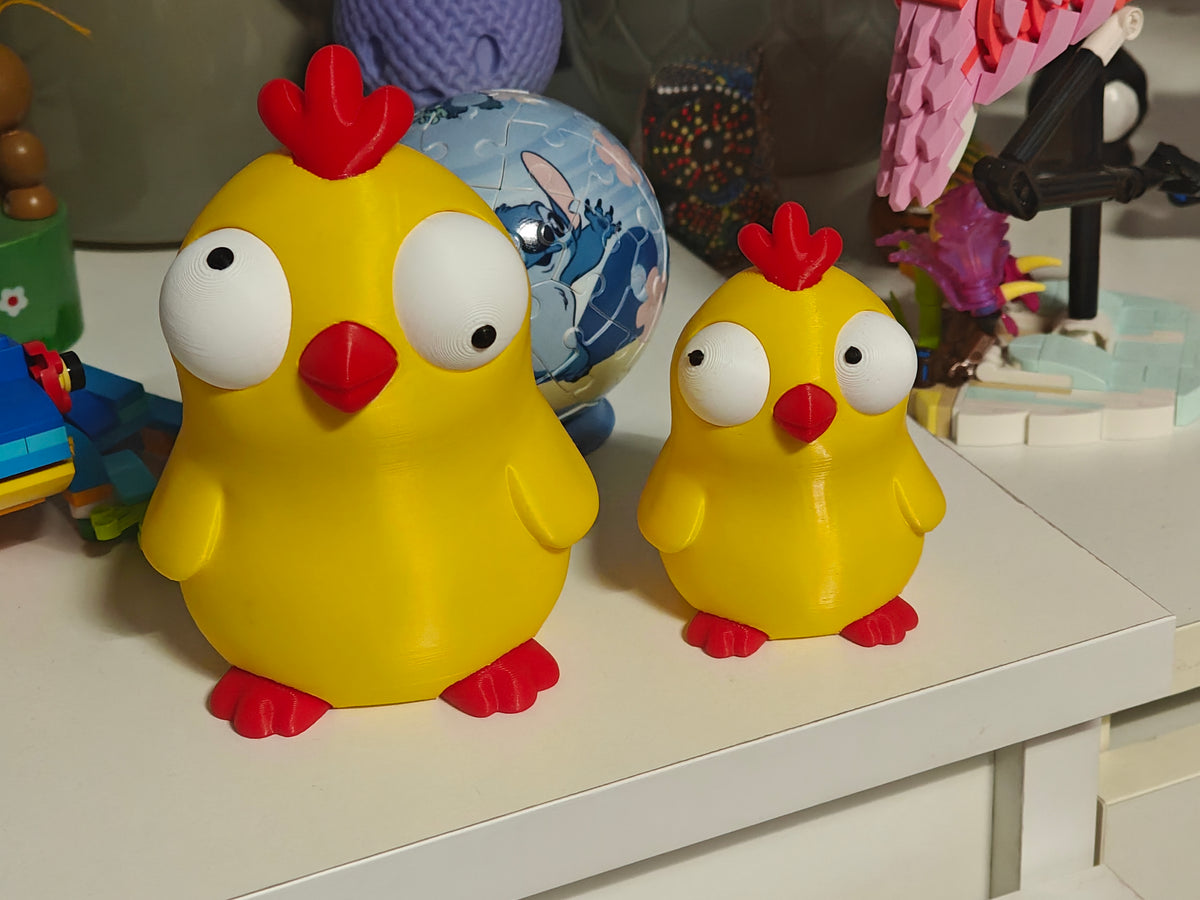 Närbild av en rolig kycklingfigur med stora rörliga googlyögon mot vit bakgrund