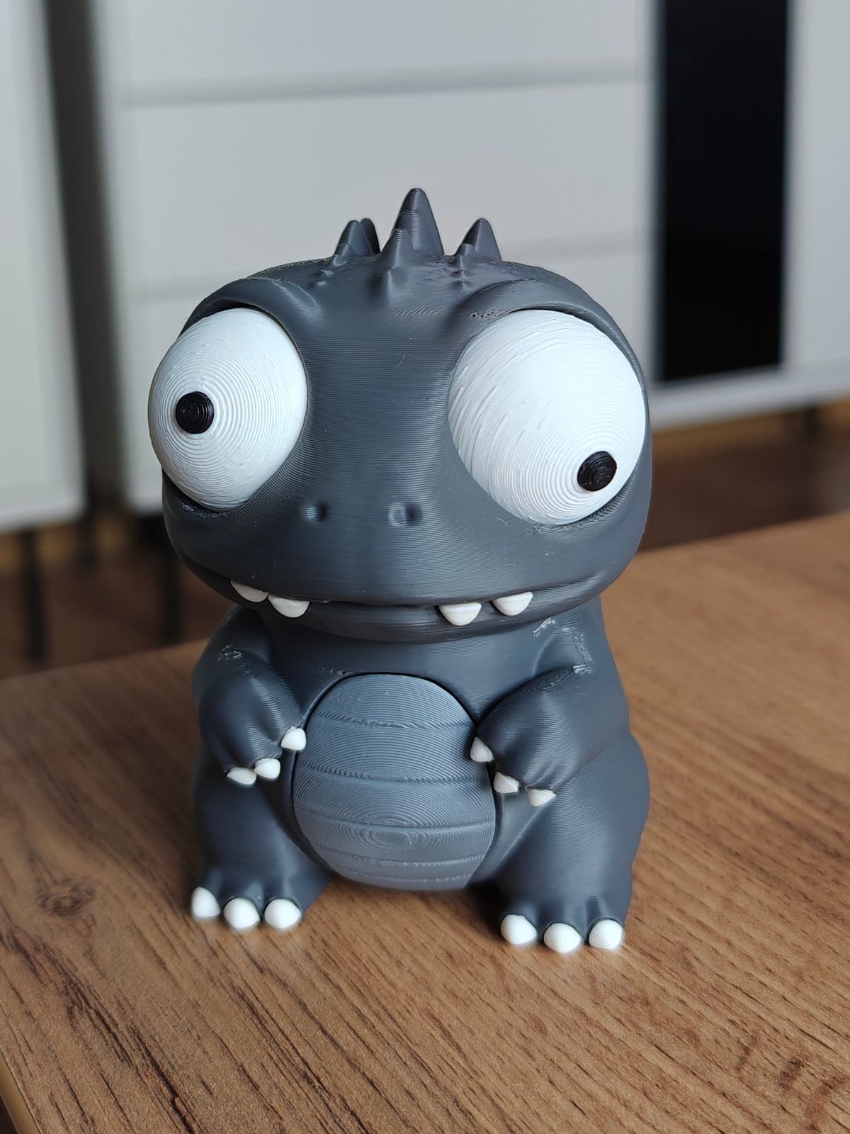 Kaiju-dinomonsterfigur med stora rörliga ögon, framifrån