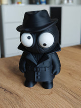 Spider Noir-figur med rörliga ögon, mörk rock och hatt, närbild mot vit bakgrund