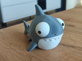 Tokig hajfigur med stora rörliga ögon på vit bakgrund