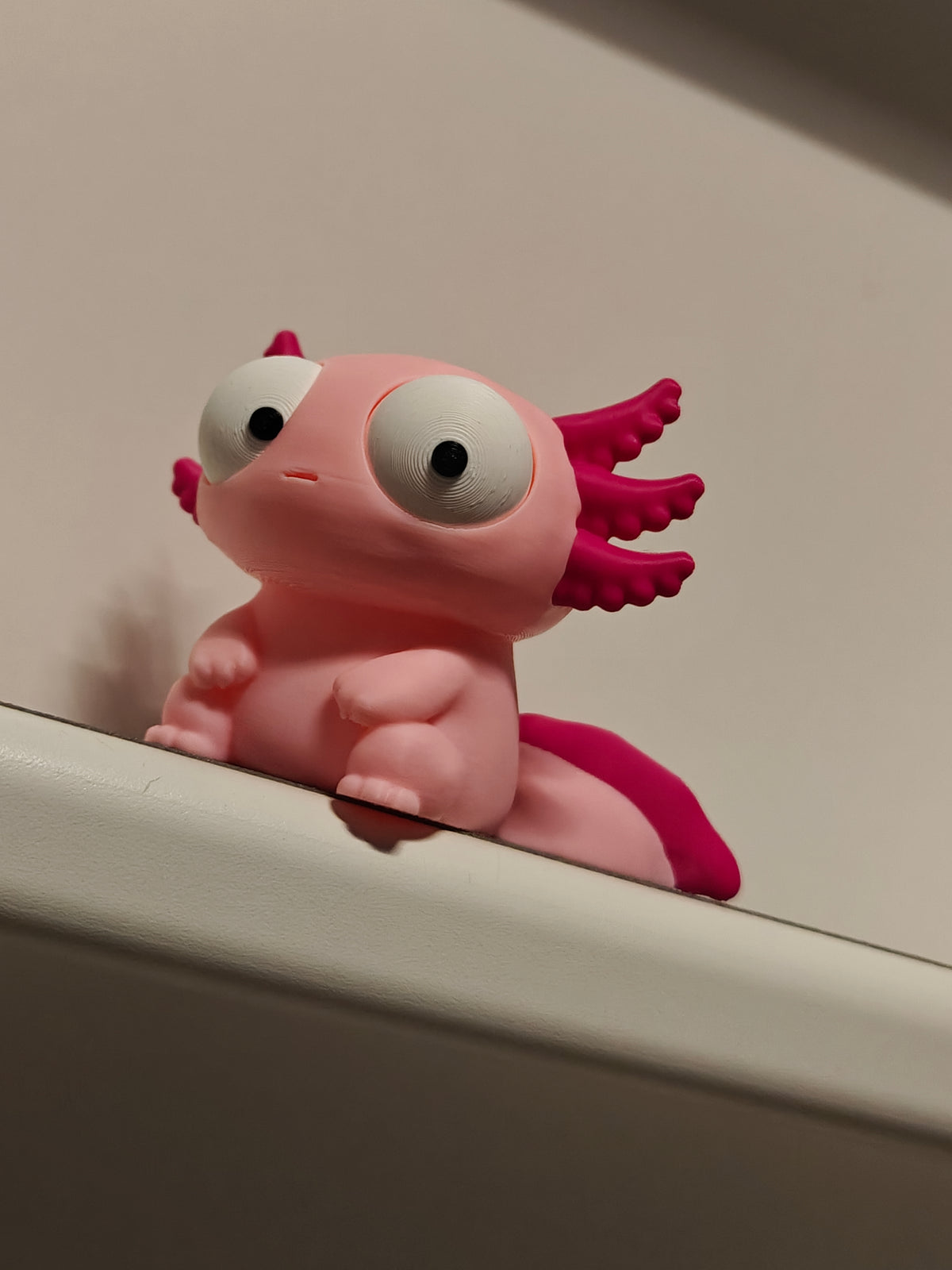 Tokig axolotlfigur med stora rörliga ögon, framifrån