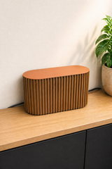 Beige kabelbox med vertikala räfflor mot vit bakgrund