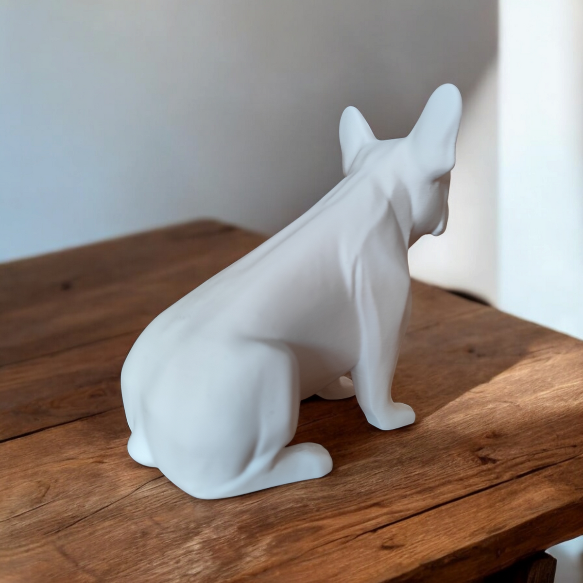 Skulptur av fransk bulldogg på vit hylla i modernt vardagsrum