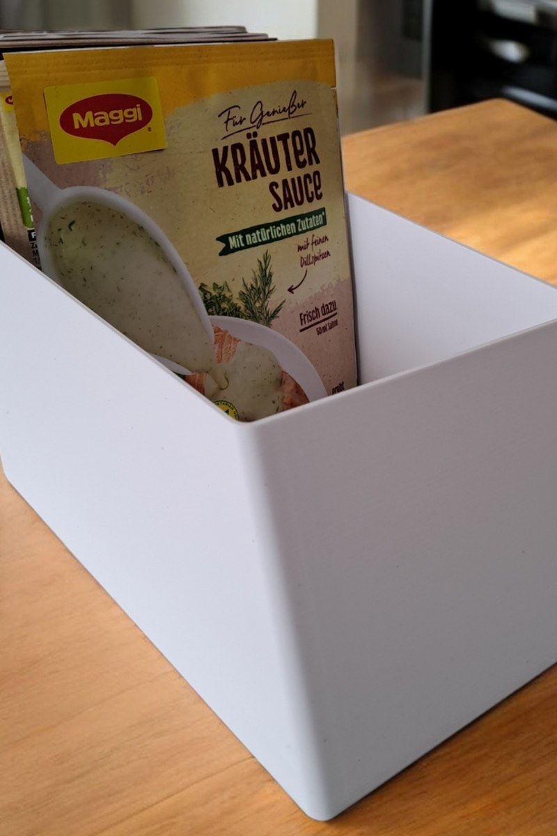 Vit köksorganisatör för ingredienser med sluttande insida och räfflad botten, närbild