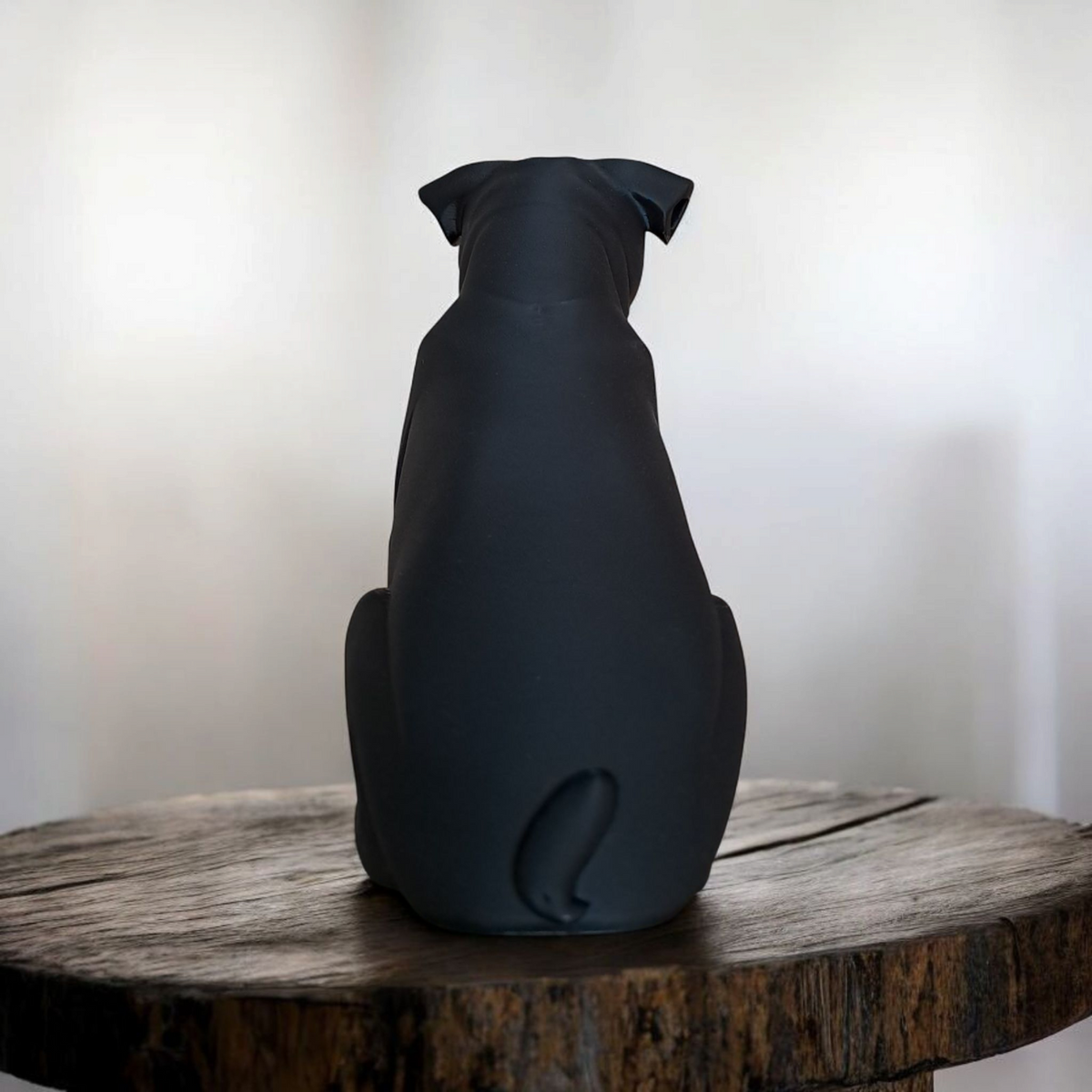 Närbild av en minimalistisk mopsskulptur med slät matt svart yta