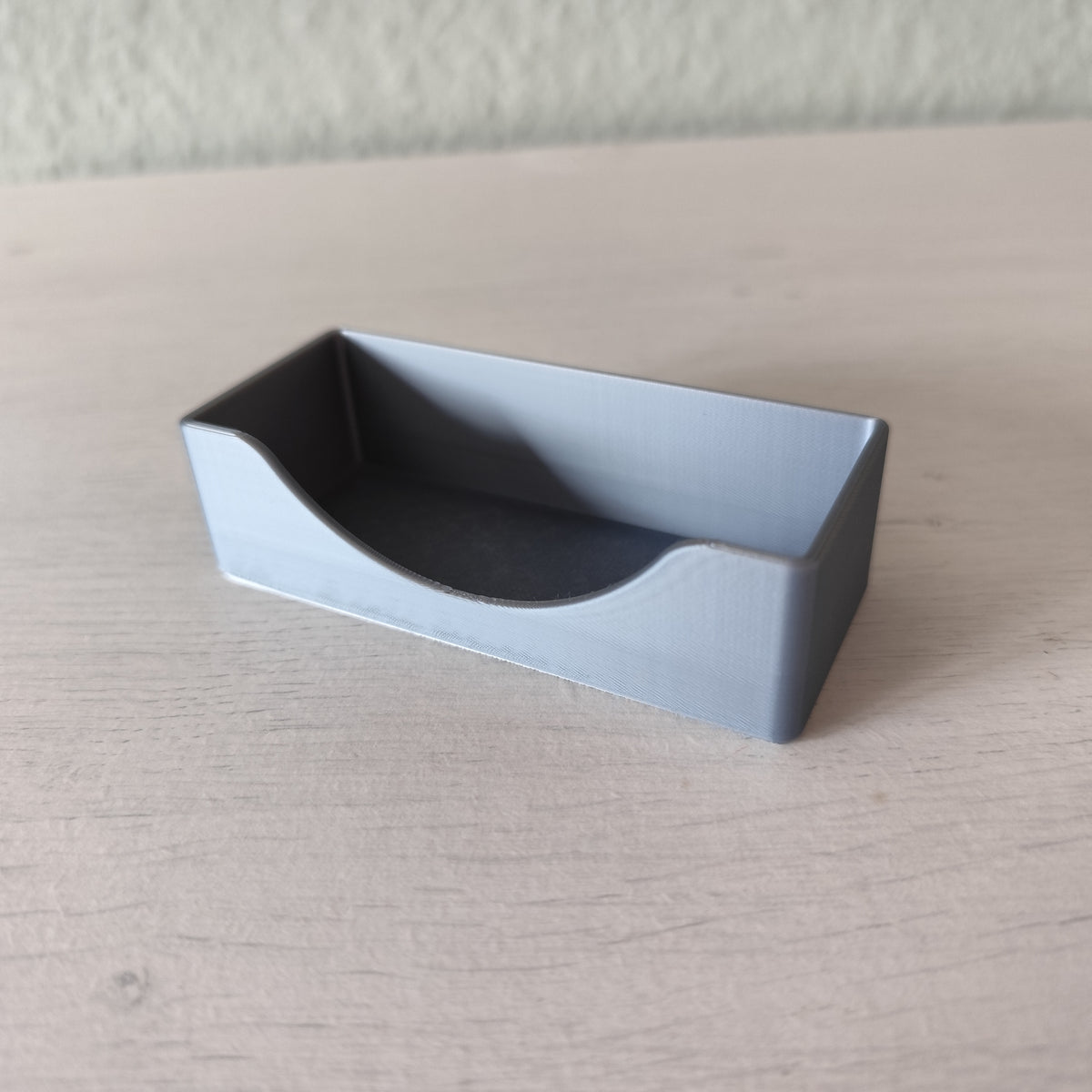 Minimalistisk visitkortshållare på ett skrivbord med visitkort i