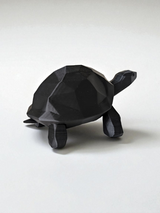 Närbild av en low poly-sköldpaddsskulptur med fasetterad yta och rena linjer