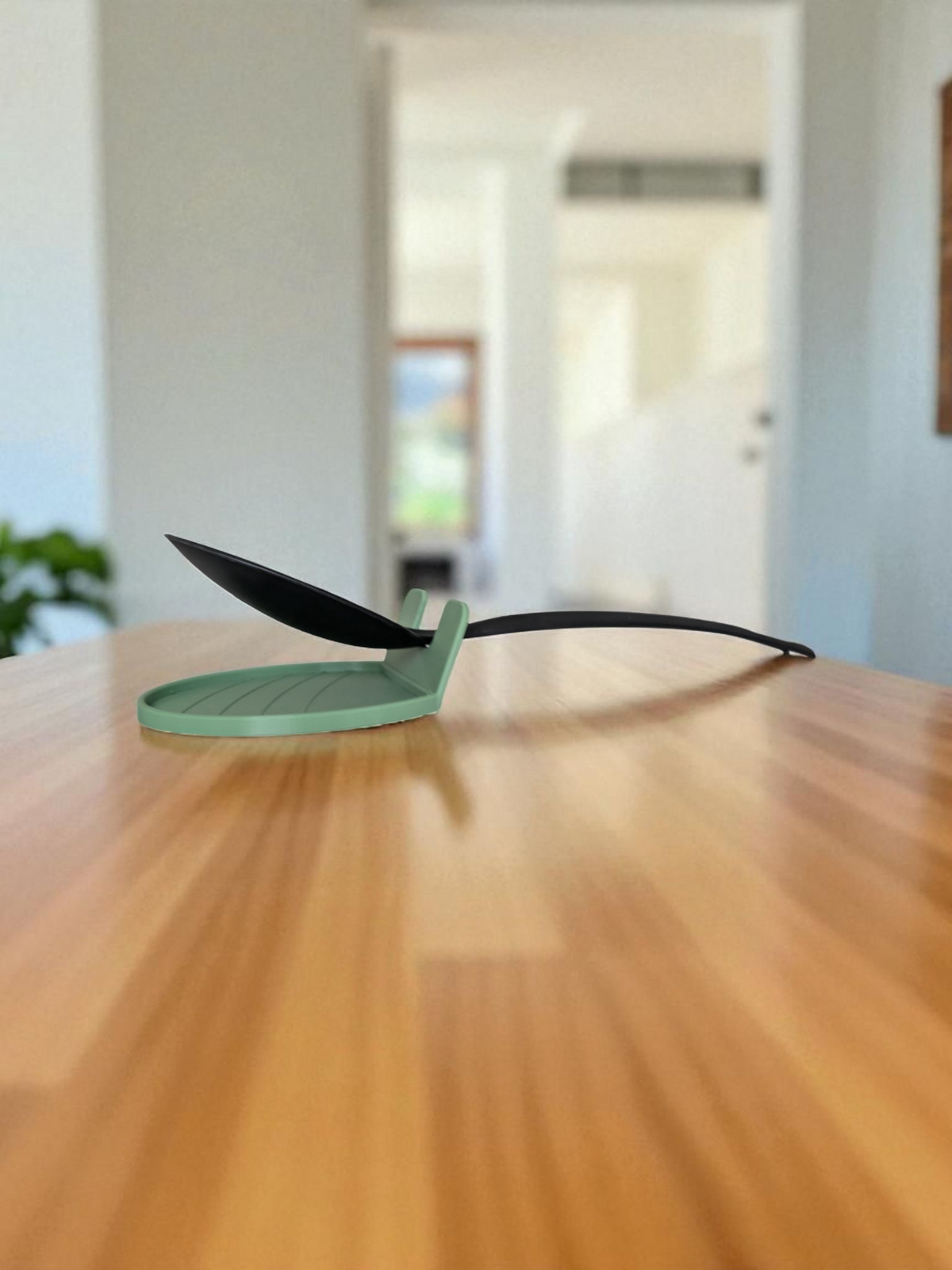 CookSitter-skedhållare bredvid spisen med en slev i