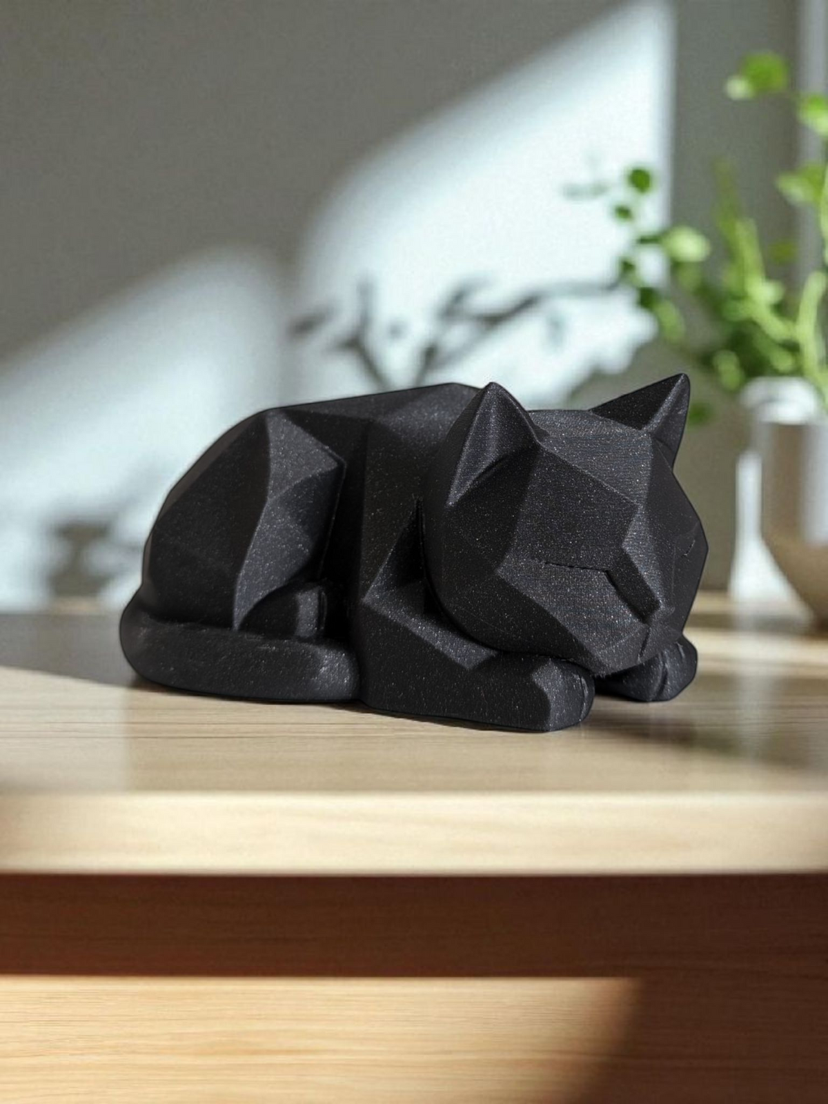 Low poly-kattungefigur på ett skrivbord i trä med minimalistisk styling