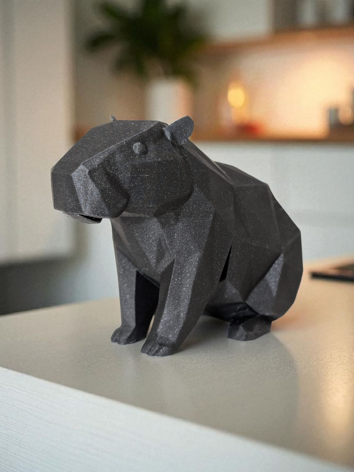 Low poly-kapybaraskulptur med geometrisk facetterad yta och lugn pose