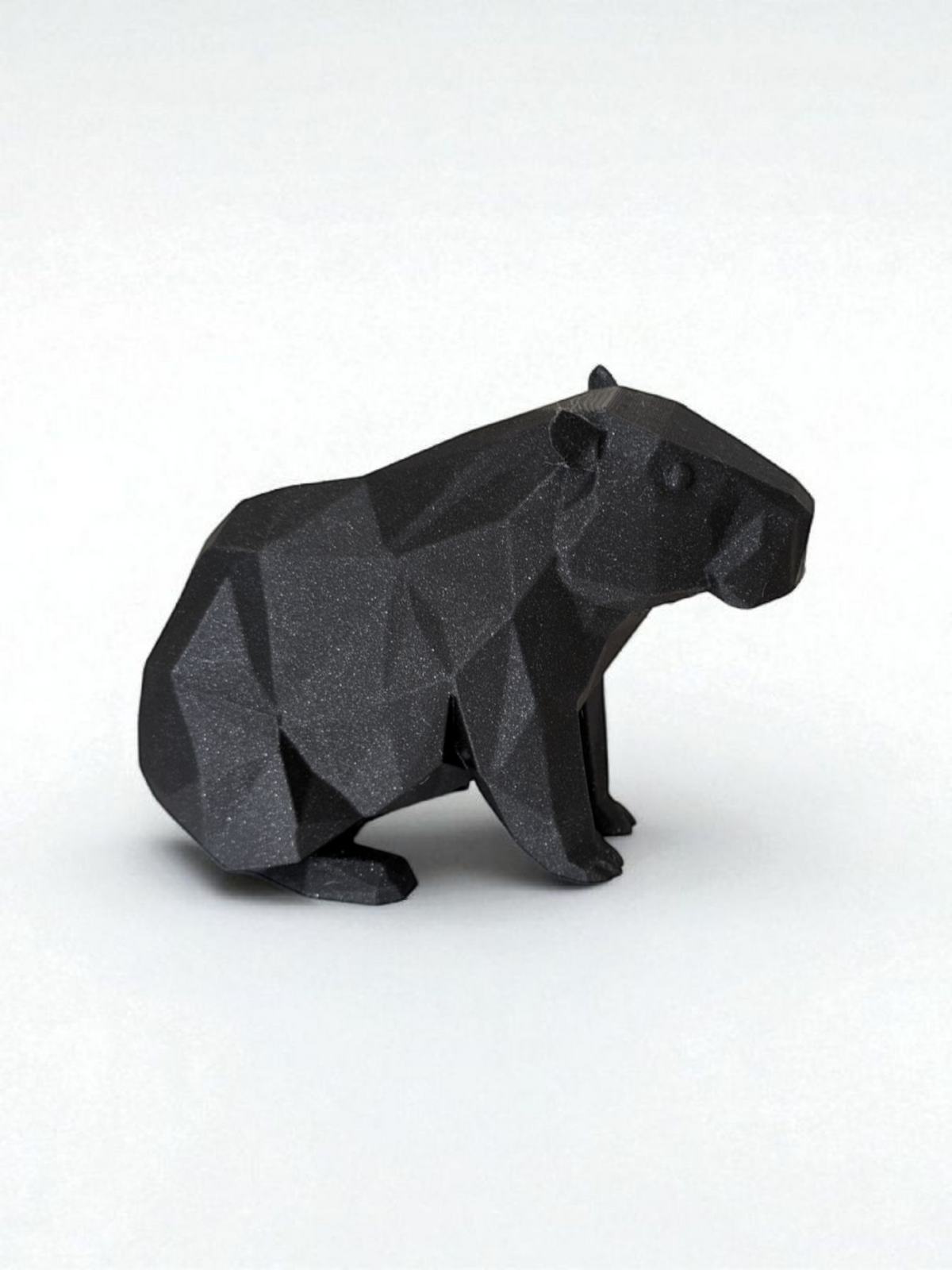Low poly-kapybaraskulptur med geometrisk facetterad yta och lugn pose
