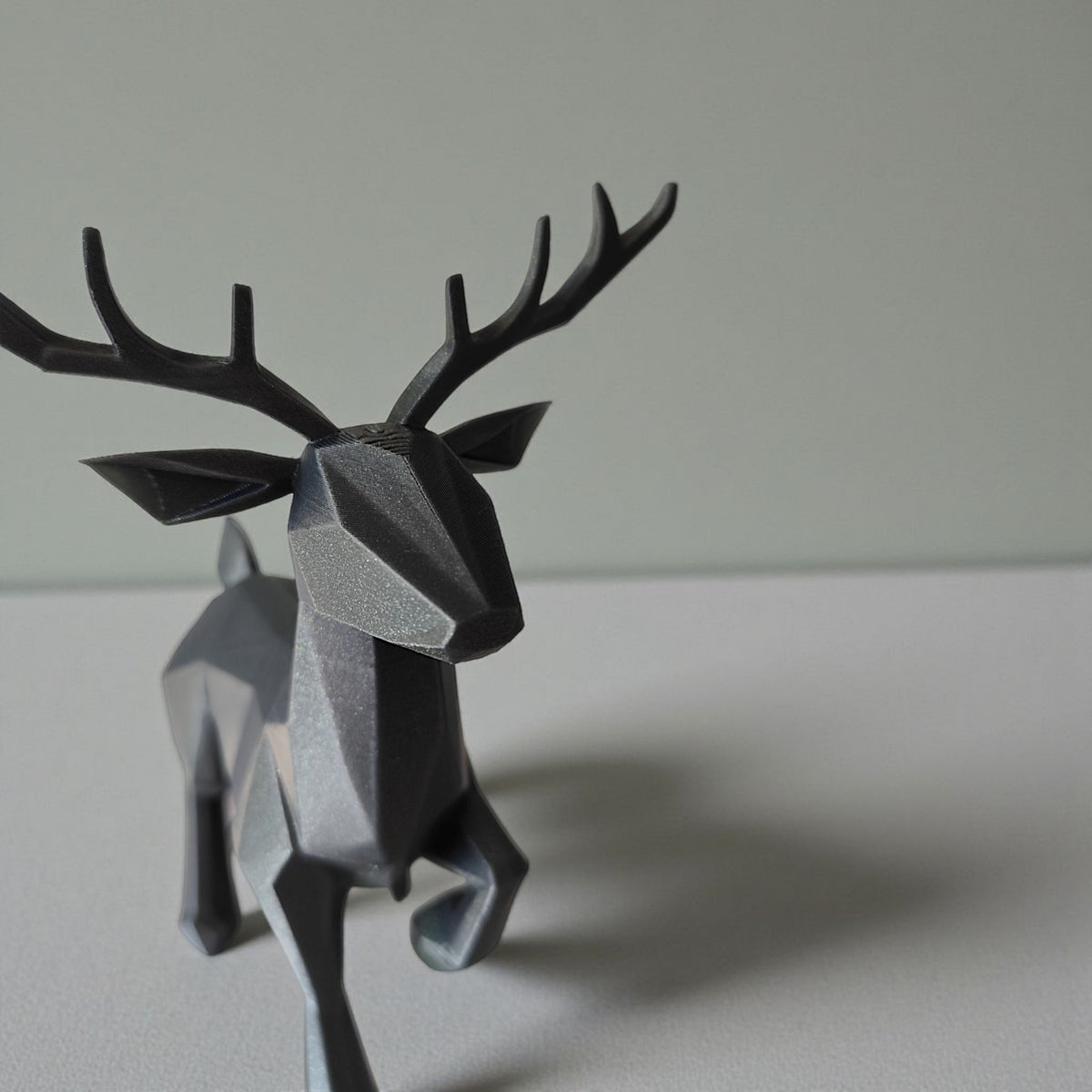 Närbild av en minimalistisk low poly-ren med fasetterad yta och horn