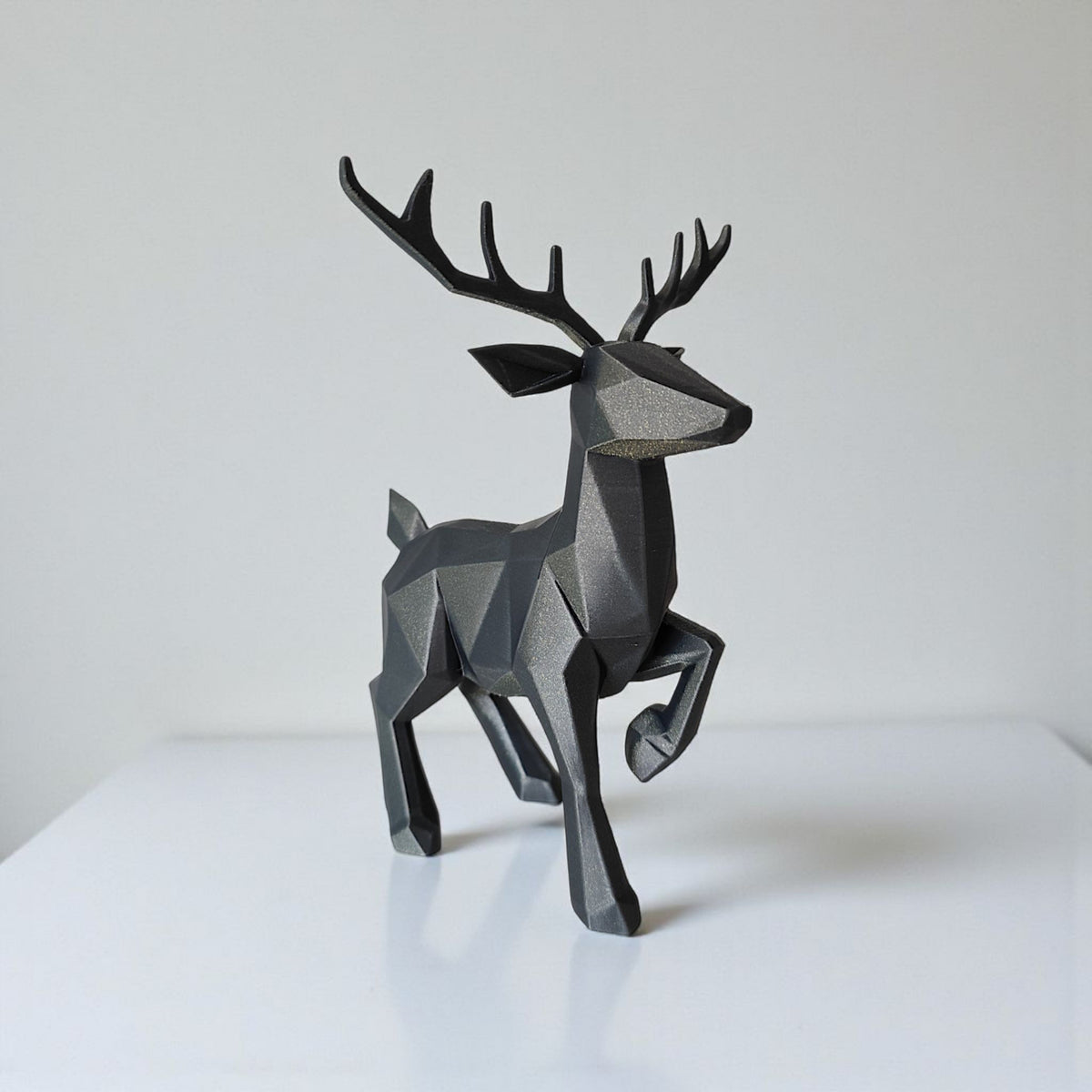 Närbild av en minimalistisk low poly-ren med fasetterad yta och horn