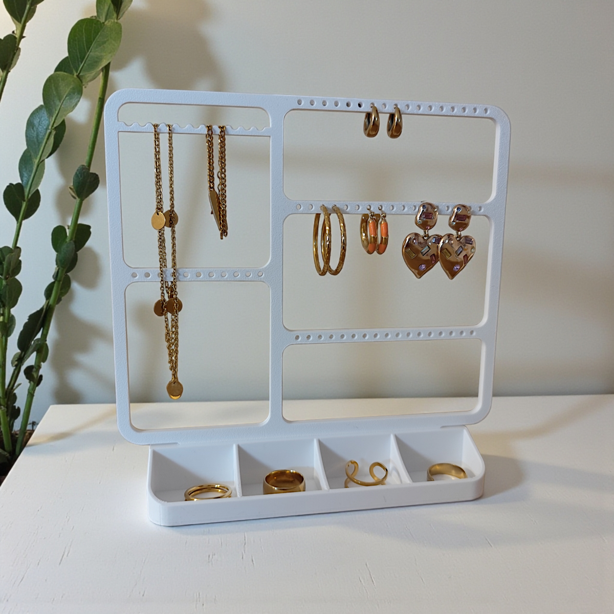 Smyckeshängare ovanför en byrå med örhängen och fina halsband