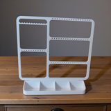 Minimalistisk smyckeshållare med örhängen, ringar och halsband i ren vit design