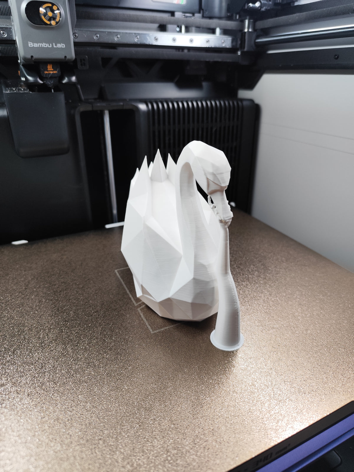 Vit low poly-svanskulptur med kantig geometrisk form, närbild
