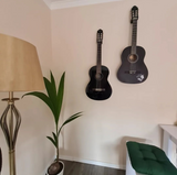 Elgitarr på vit vägg i diskret minimalistisk hållare