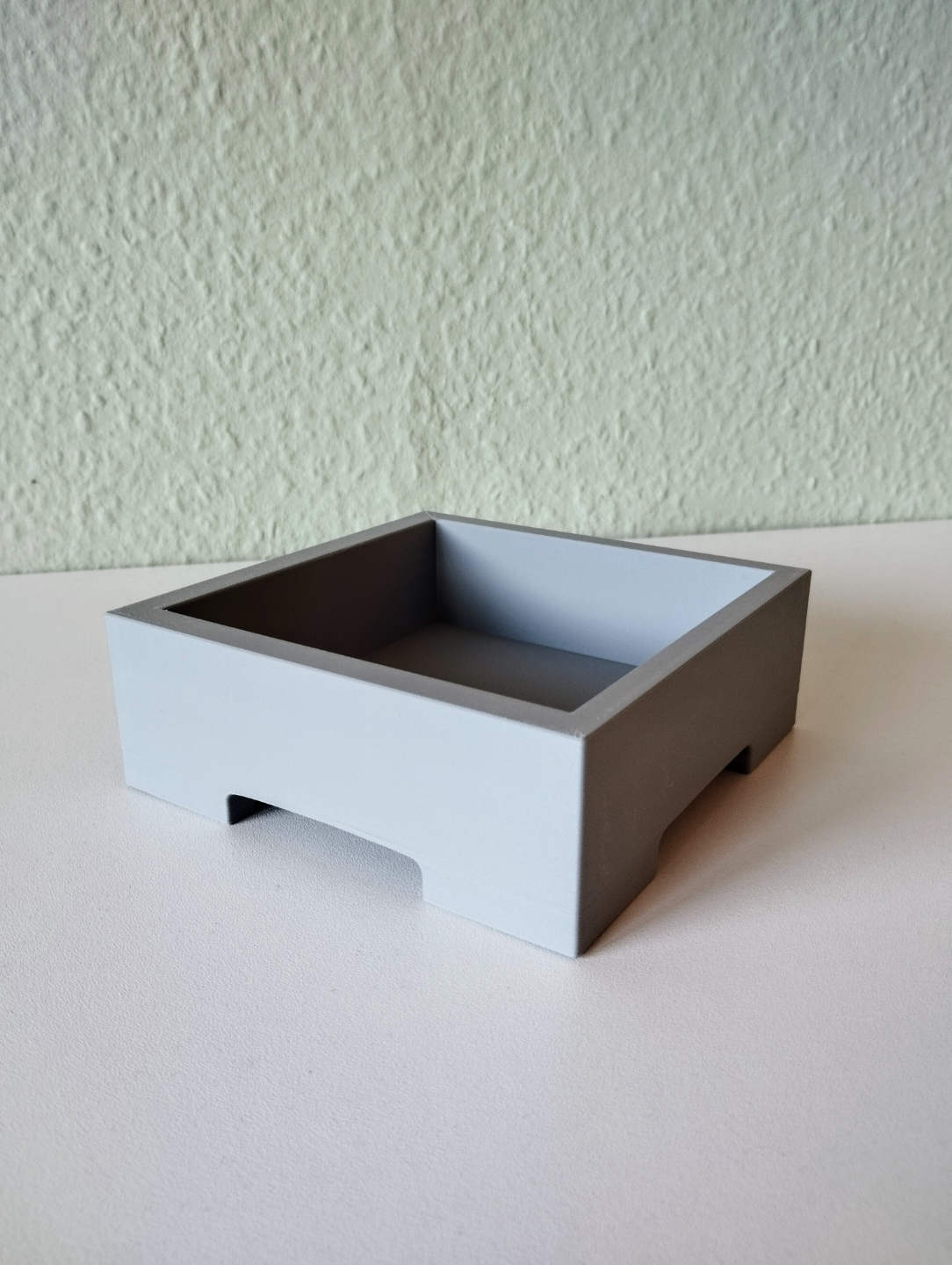 Minimalistisk bonsaikruka med en liten växt på en ljus trähylla
