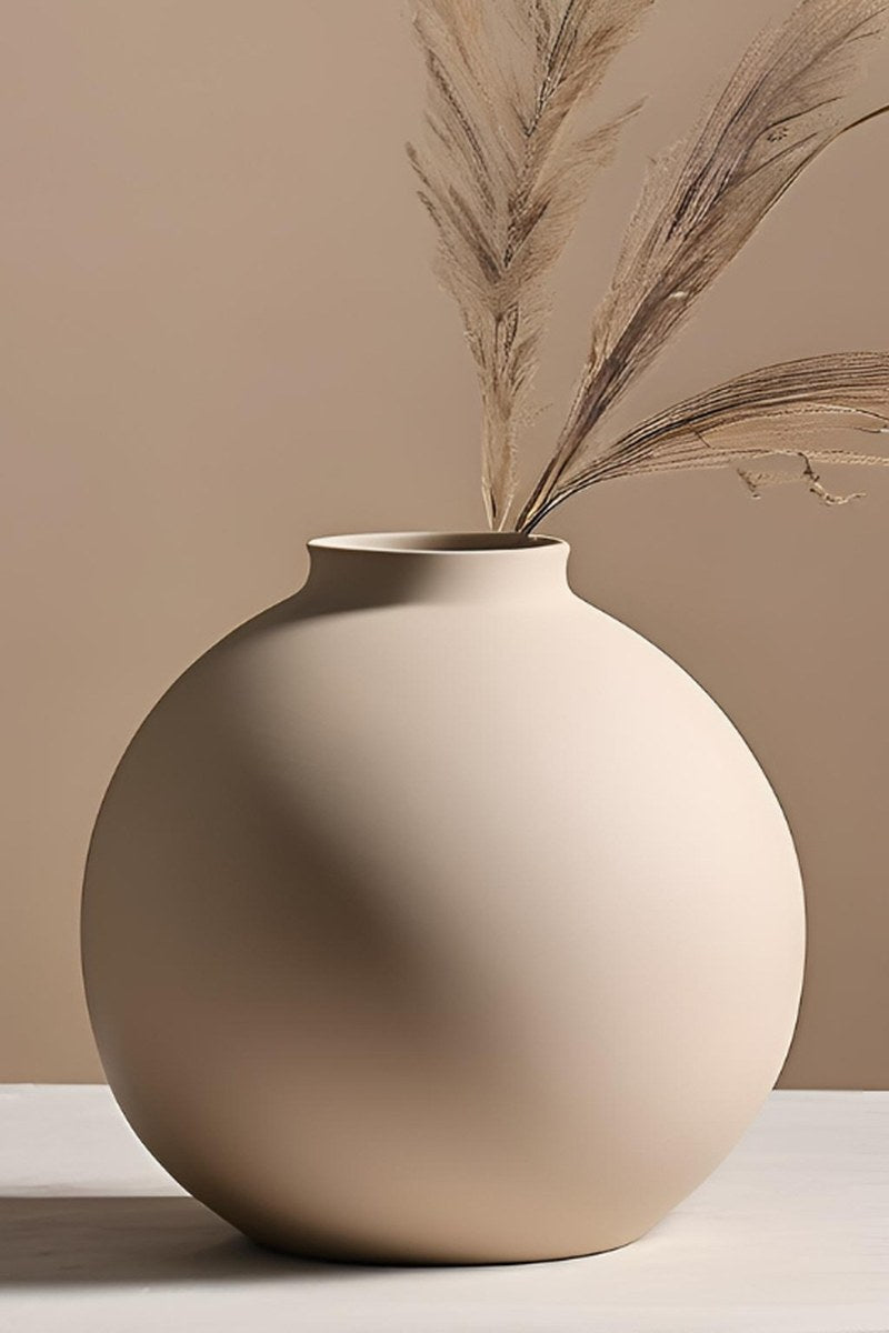 Närbild av en minimalistisk rund vas med slät klotform