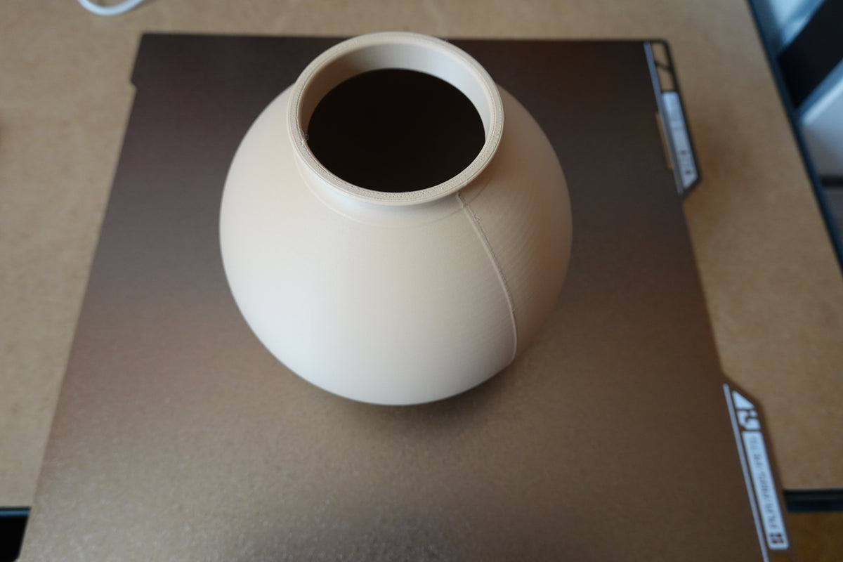 Närbild av en minimalistisk rund vas med slät klotform