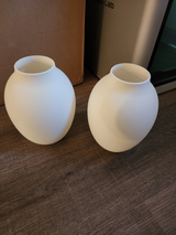 Modern amforavas på en vit hylla i minimalistisk miljö