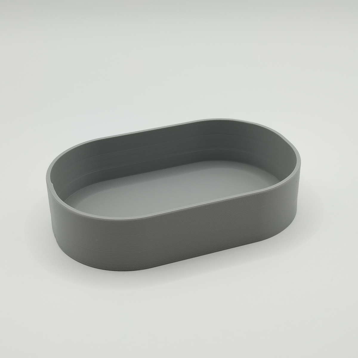 Minimalistisk nyckelbricka i en modern hall med nycklar i och en trähylla i bakgrunden