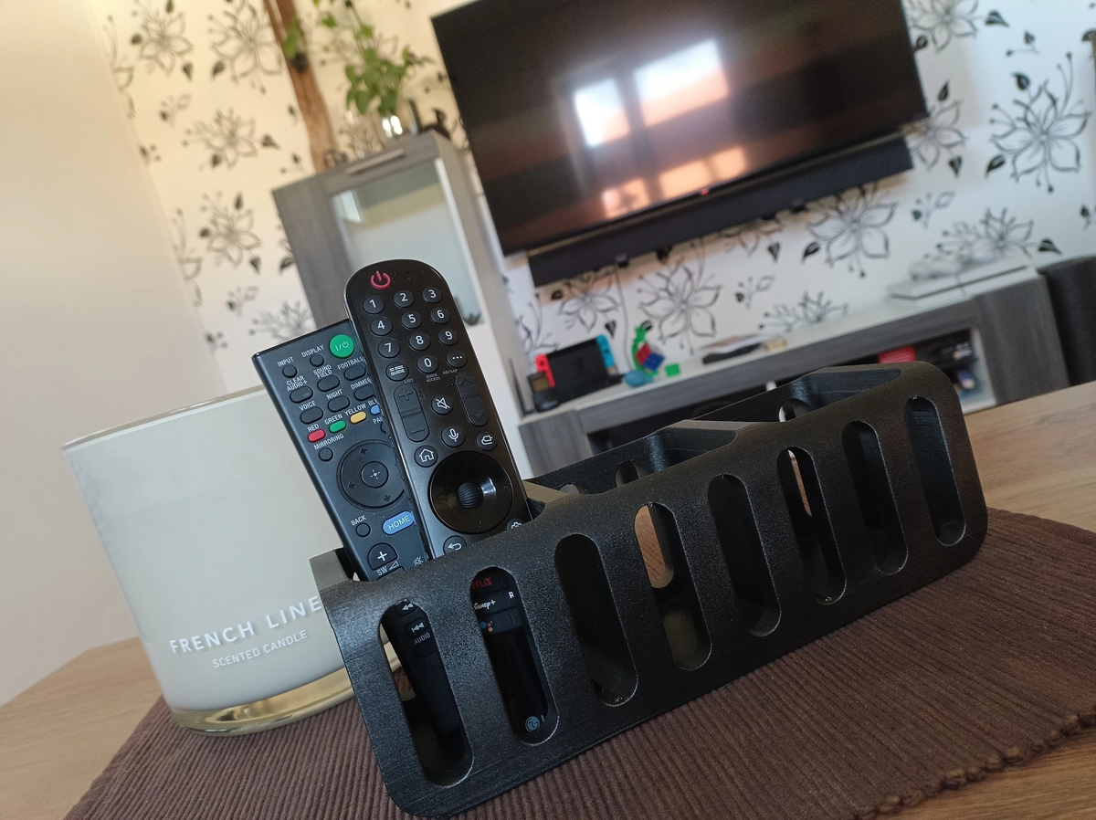 Fjärrkontrollshållare på ett sidobord i vardagsrummet bredvid en växt