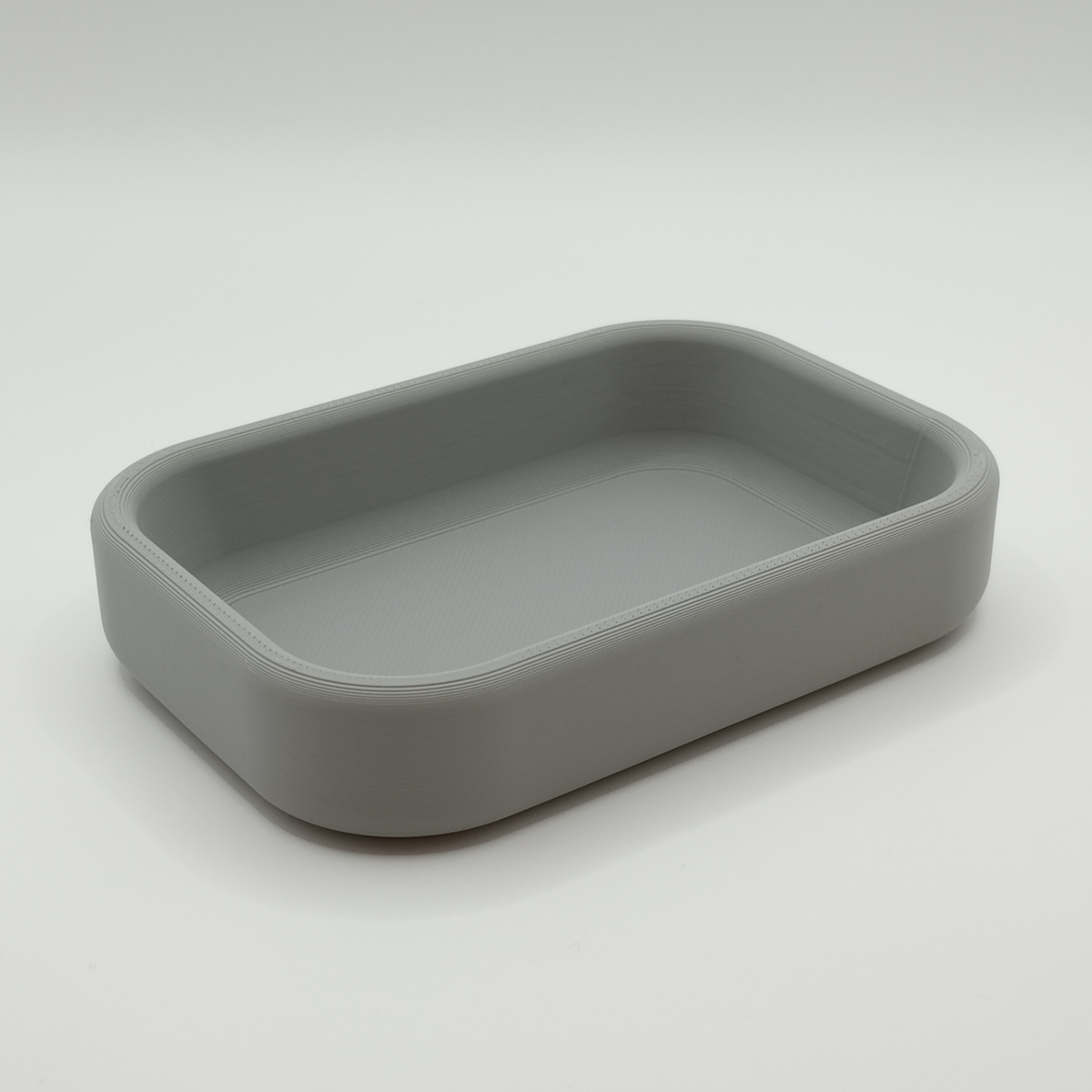 Minimalistisk nyckelbricka på en hallkonsol med nycklar och en växt