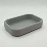 Minimalistisk nyckelbricka på en hallkonsol med nycklar och en växt