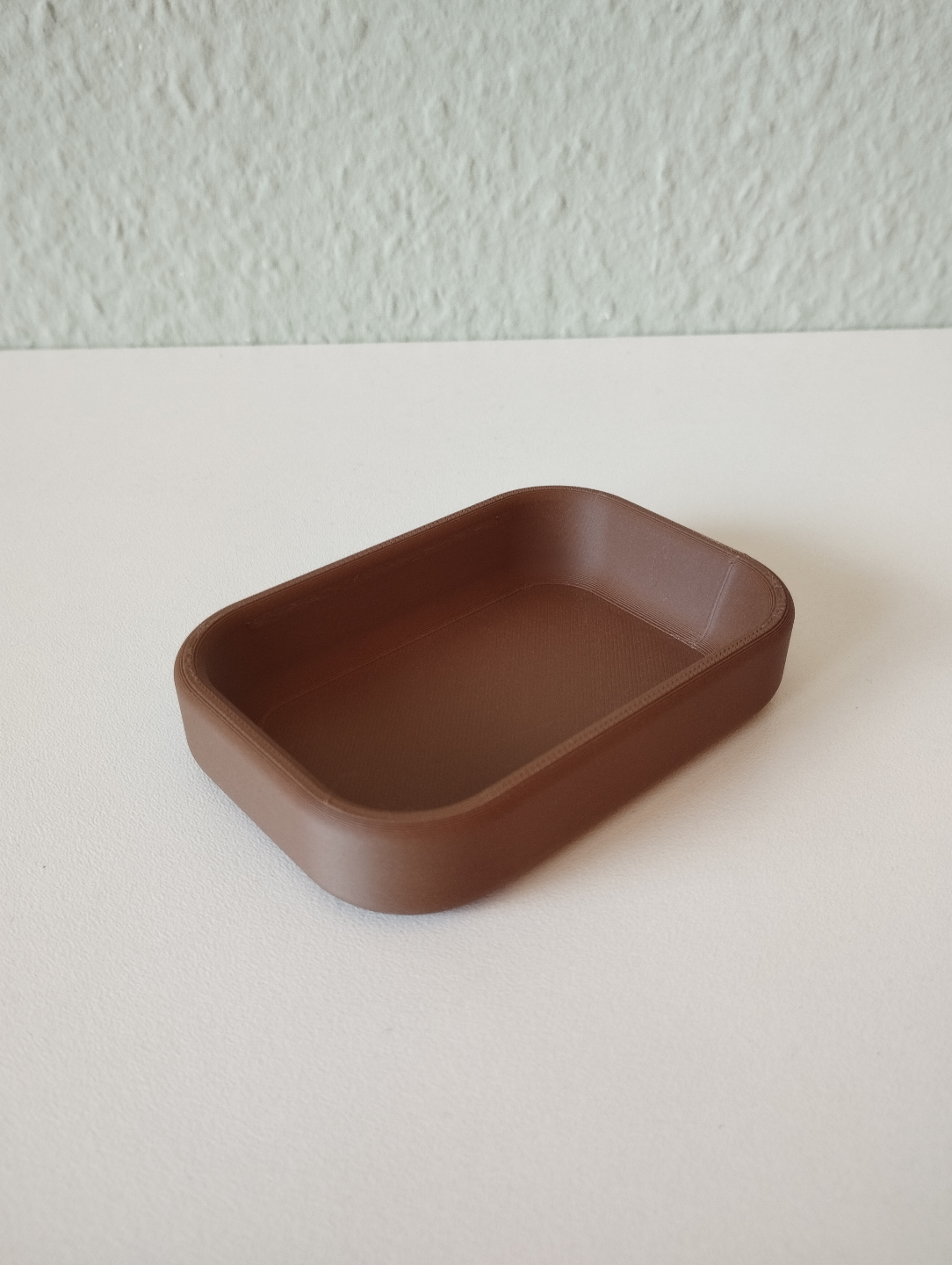 Modern nyckelbricka i mjuk neutral ton, närbild av den släta ytan