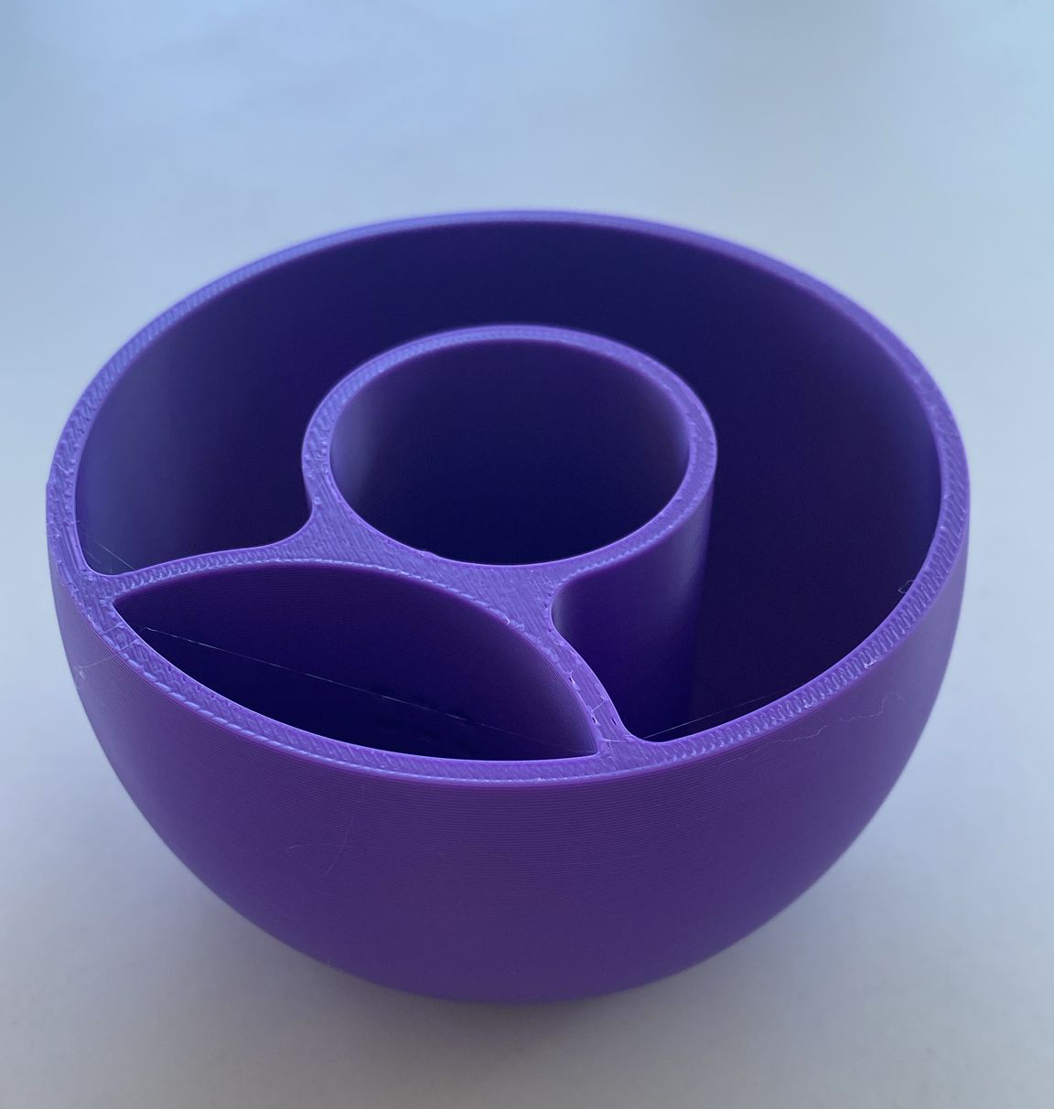 Minimalistisk självbevattnande kruka på en trähylla med en liten grön växt