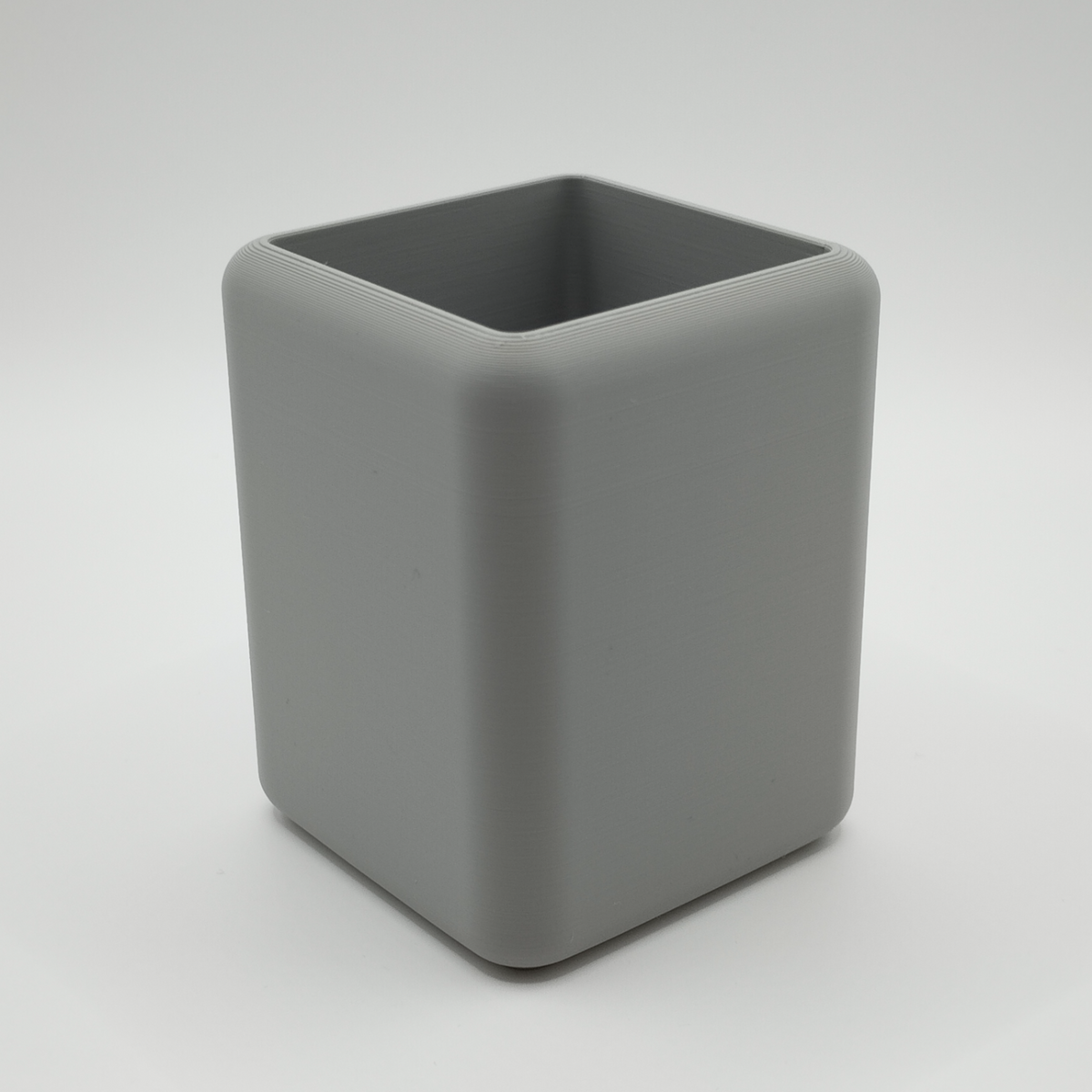Minimalistisk pennhållare på ett skrivbord med skrivdon och anteckningsbok