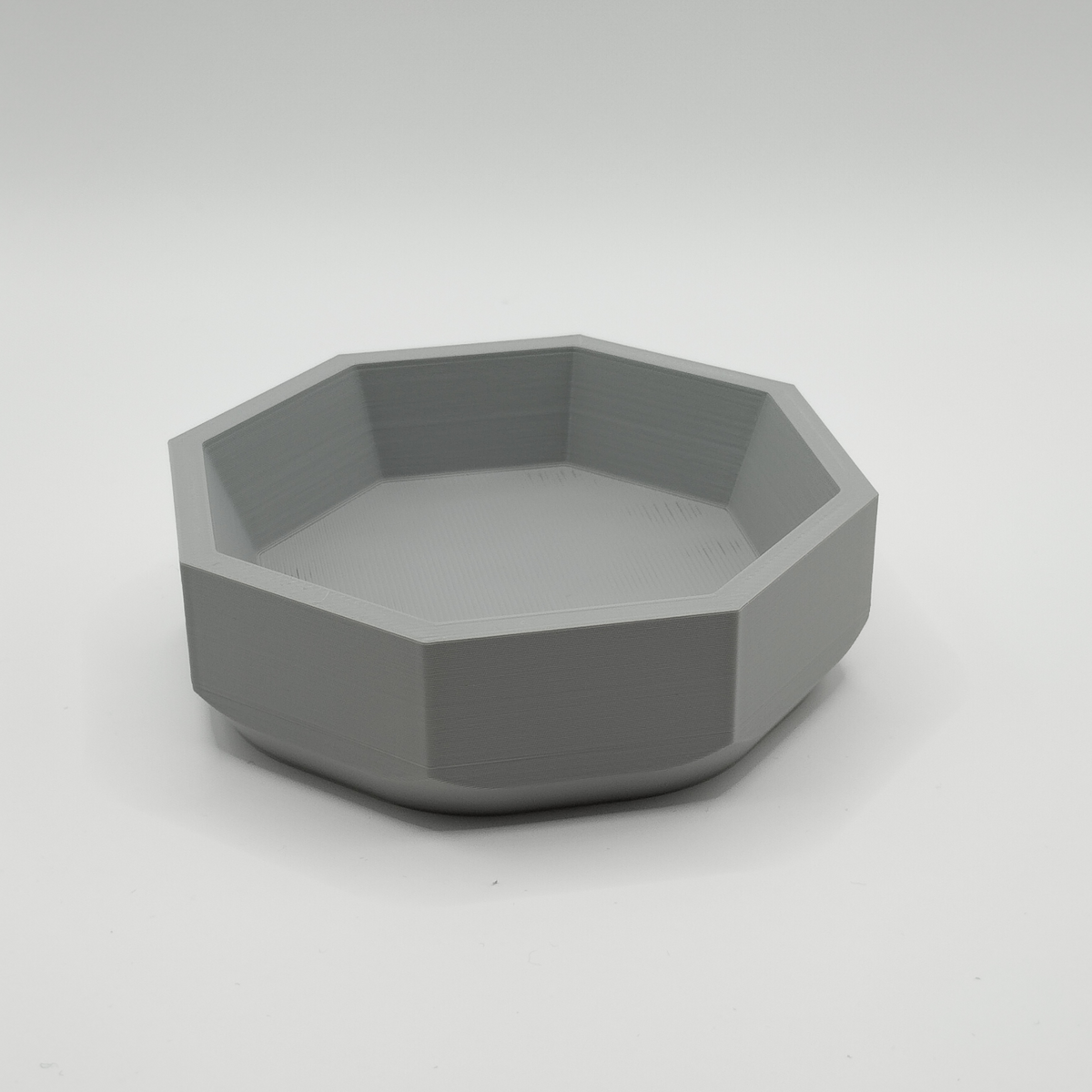 Minimalistisk geometrisk skål på en trähylla i modern miljö