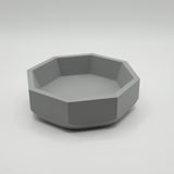 Minimalistisk geometrisk skål på en trähylla i modern miljö