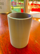 Räfflad pennhållare på ett skrivbord med pennor och minimalistisk arbetsplats
