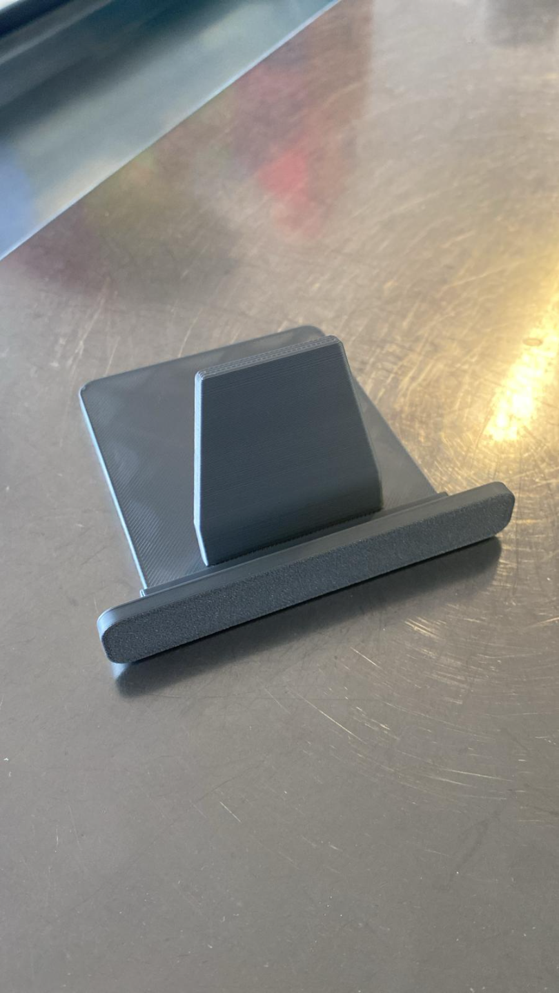 Minimalistiskt vitt surfplatteställ från sidan med geometrisk form och vinkel