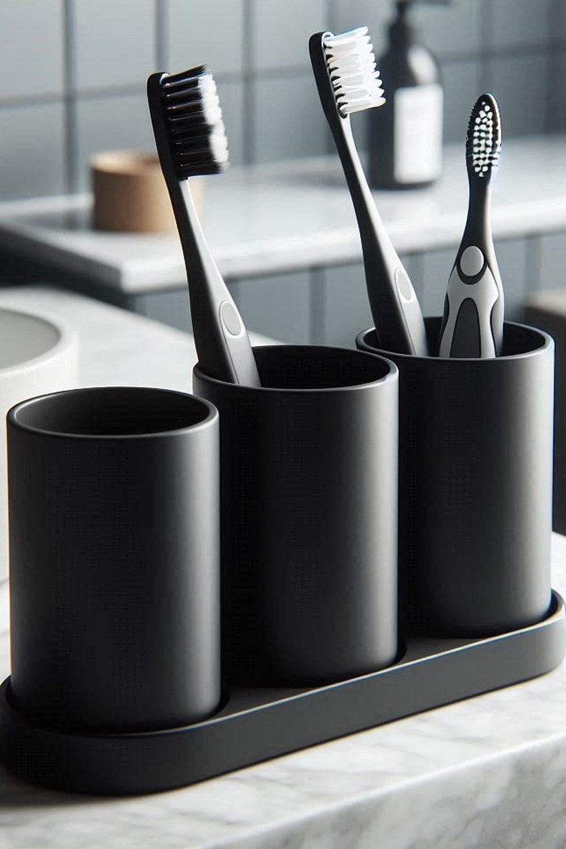 Närbild av ett vitt tandborsthållarset med tre cylinderformade muggar och underlägg