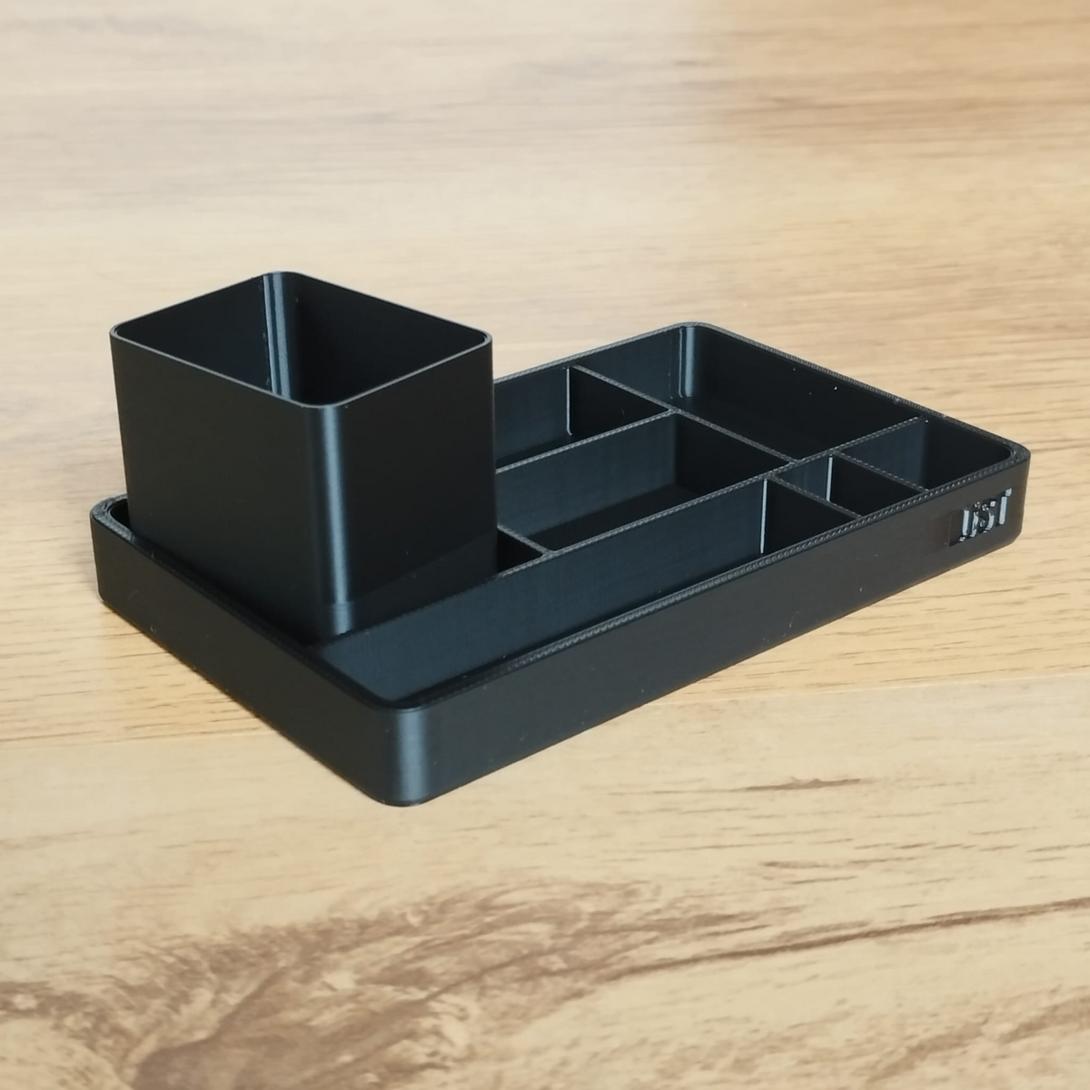 Närbild av en minimalistisk kontorsbricka och pennkopp med rena linjer
