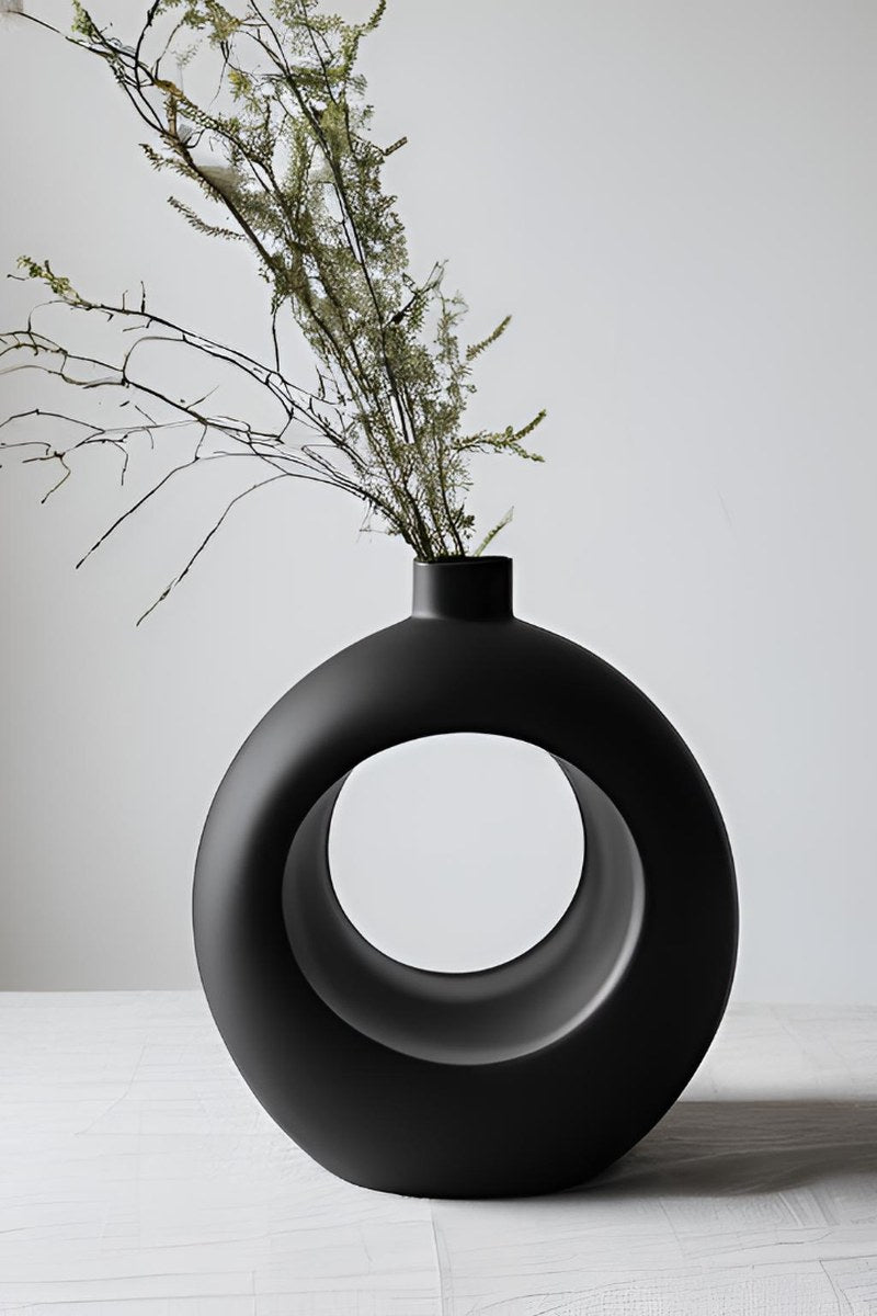 Närbild av en minimalistisk ringvas med geometrisk form och cirkulär öppning