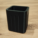 Närbild av en minimalistisk fyrkantig pennhållare med räfflade sidor