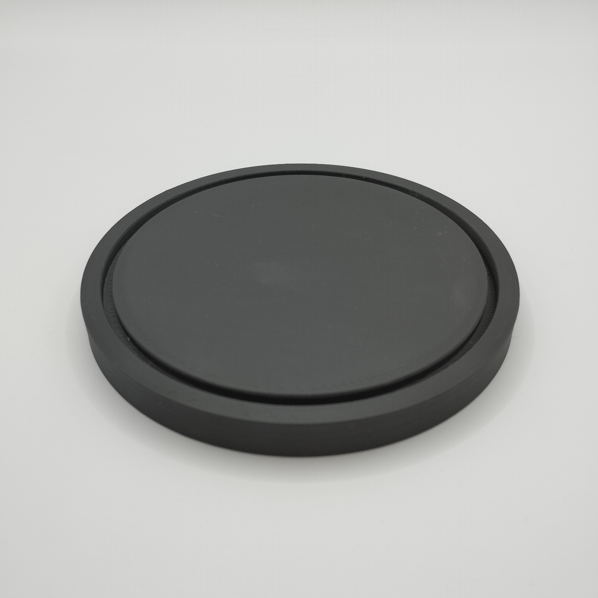 Minimalistiskt runt underlägg under en varm keramikmugg på ett träbord