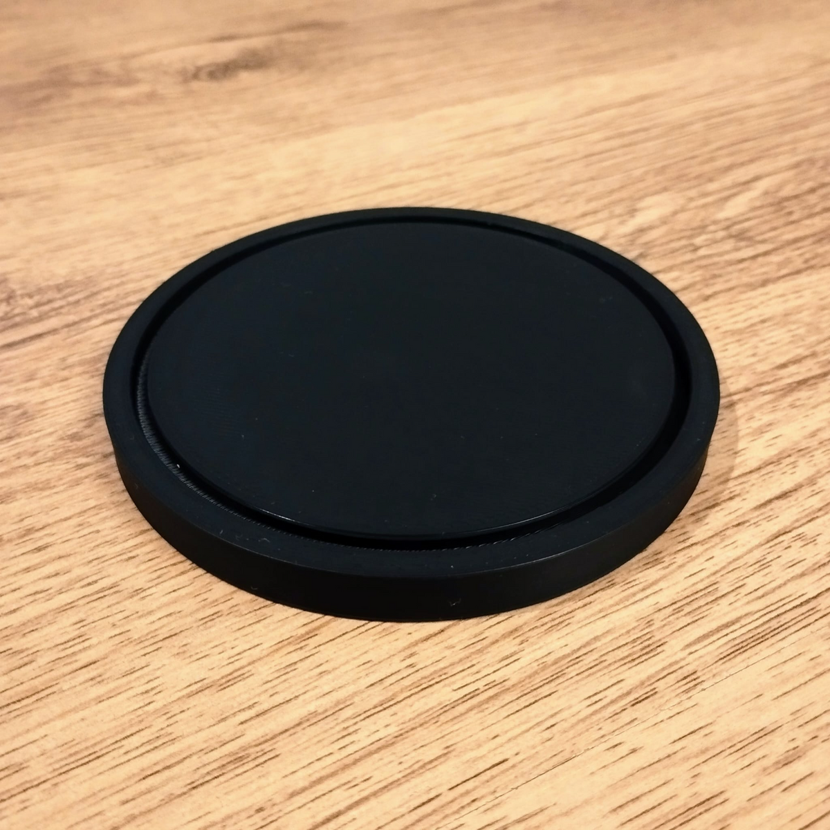 Slätt runt minimalistiskt underlägg sett ovanifrån, ren geometri och matt yta