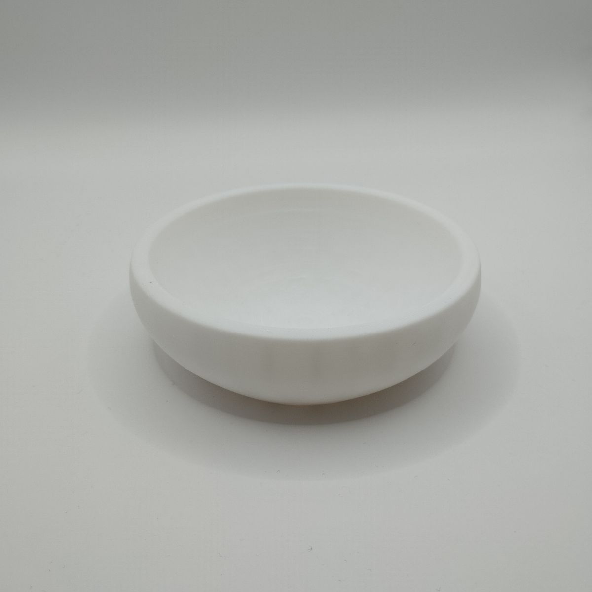 Minimalistisk skål för nycklar och mynt på ett hallbord med utspridda nycklar