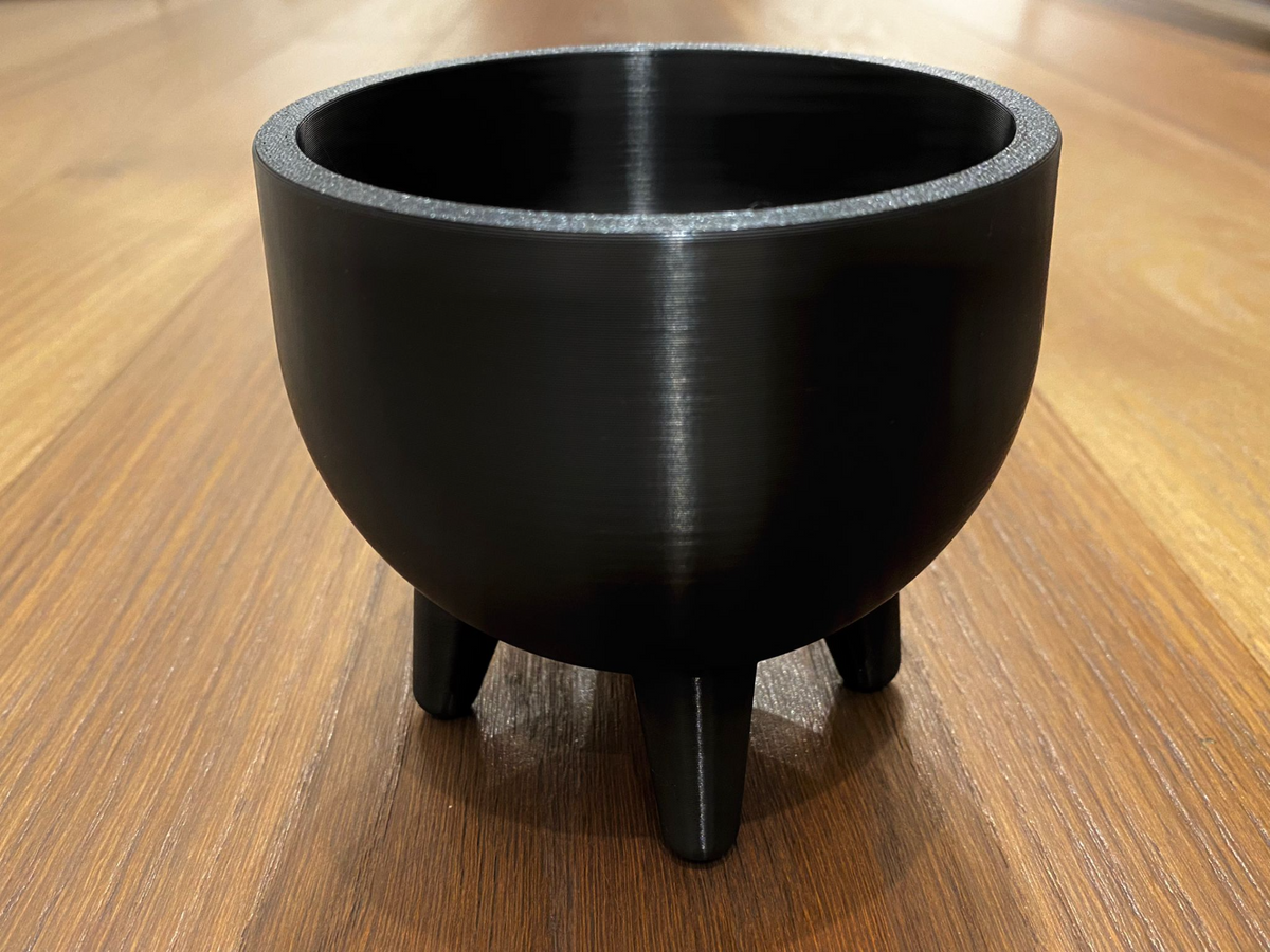 Mid century-kruka med fyra ben i varmt ljus, rena geometriska linjer