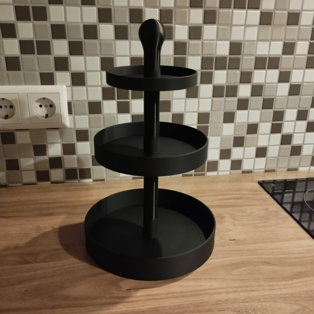 Närbild av ett tårtställ i tre våningar med geometriska proportioner och rena linjer