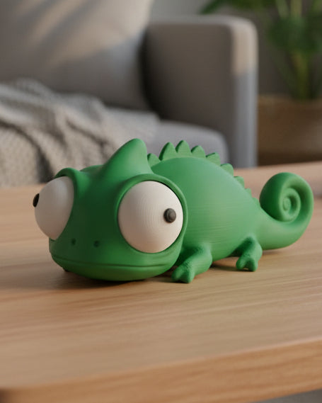 Närbild av en rolig kameleontfigur med stora rörliga googlyögon på vit yta