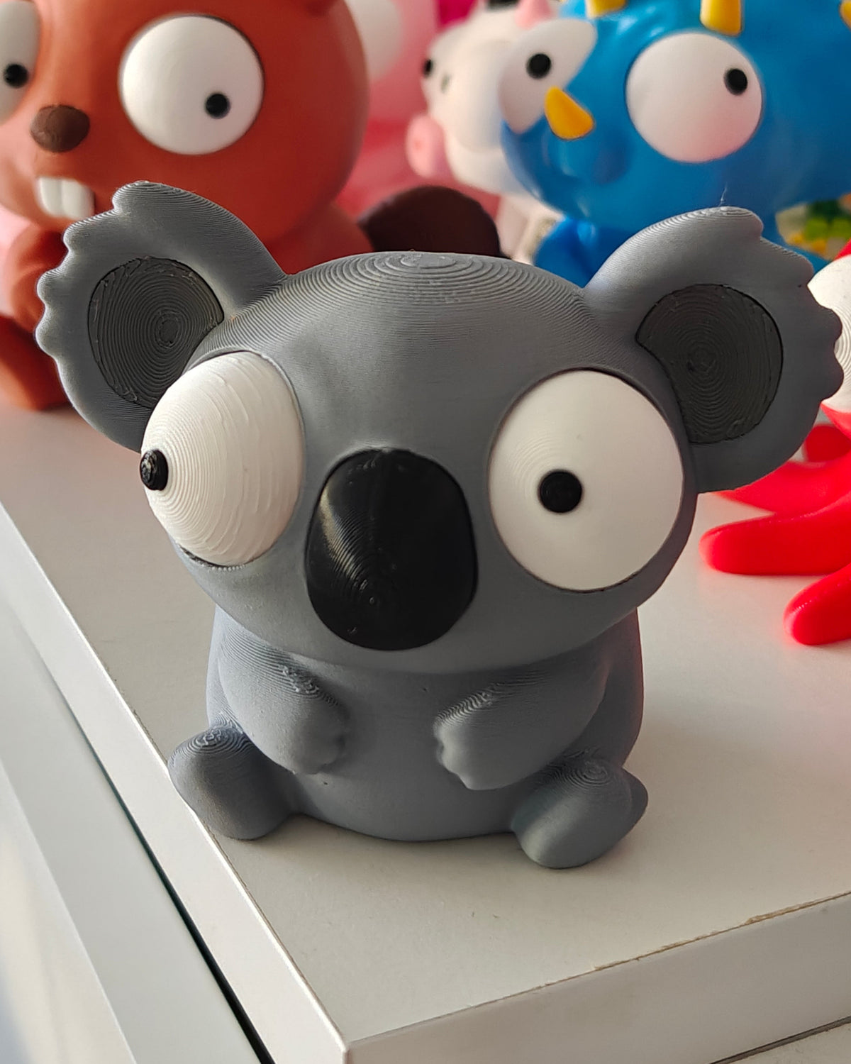 Närbild av koalafigurens stora flyttbara googlyögon med olika uttryck