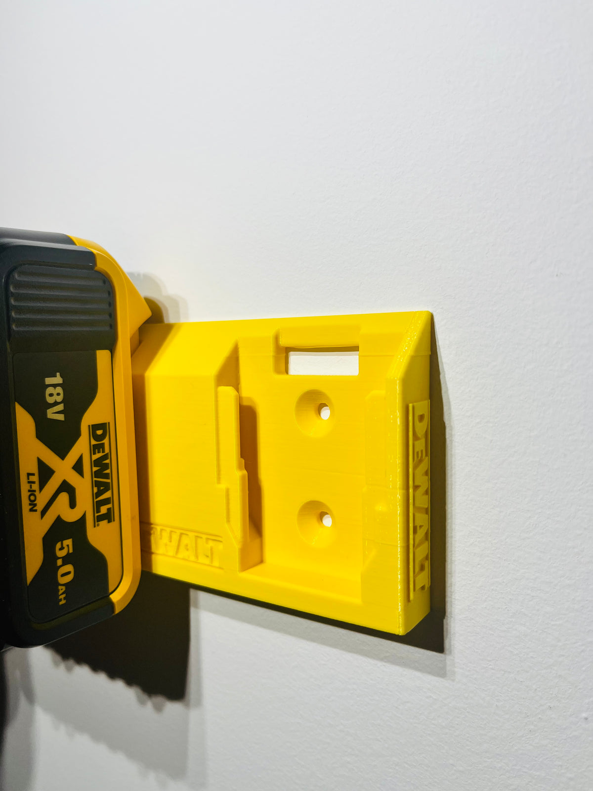 Väggfäste för två DeWalt 18V-batterier med logga