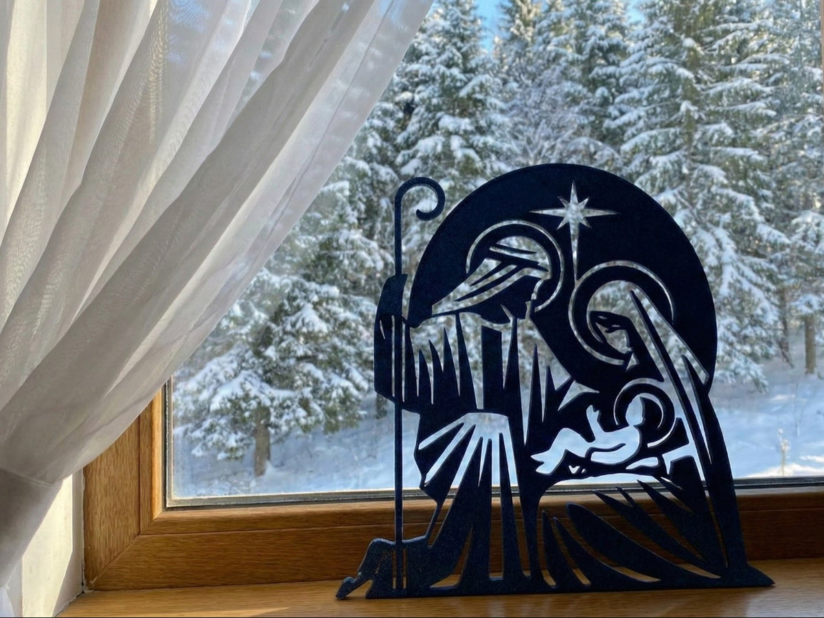 Julkrubba i siluett med Josef, Maria, Jesusbarnet och stjärna